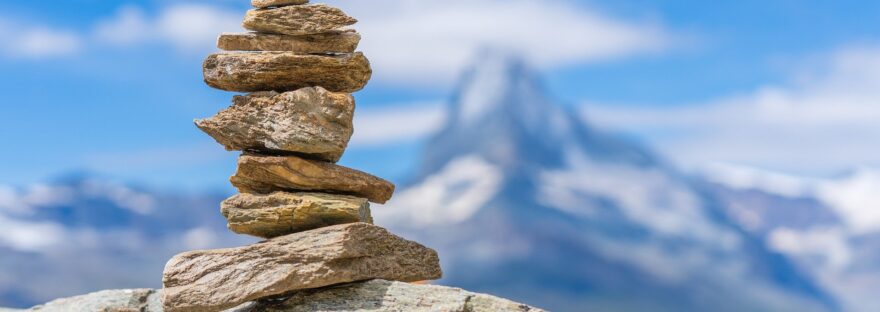 Small tower of stacked rocks, mountain landscape in the background